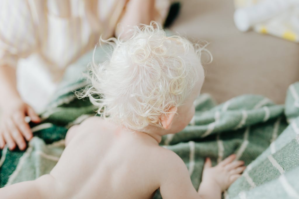 bébé blond sur le ventre pour tester le réflexe de Pérez