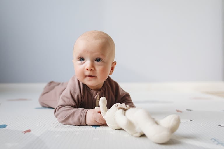 tummy-time-de-bébé-sur-le-ventre-redressant-la-tete-avec-son-doudou-lapin-blanc